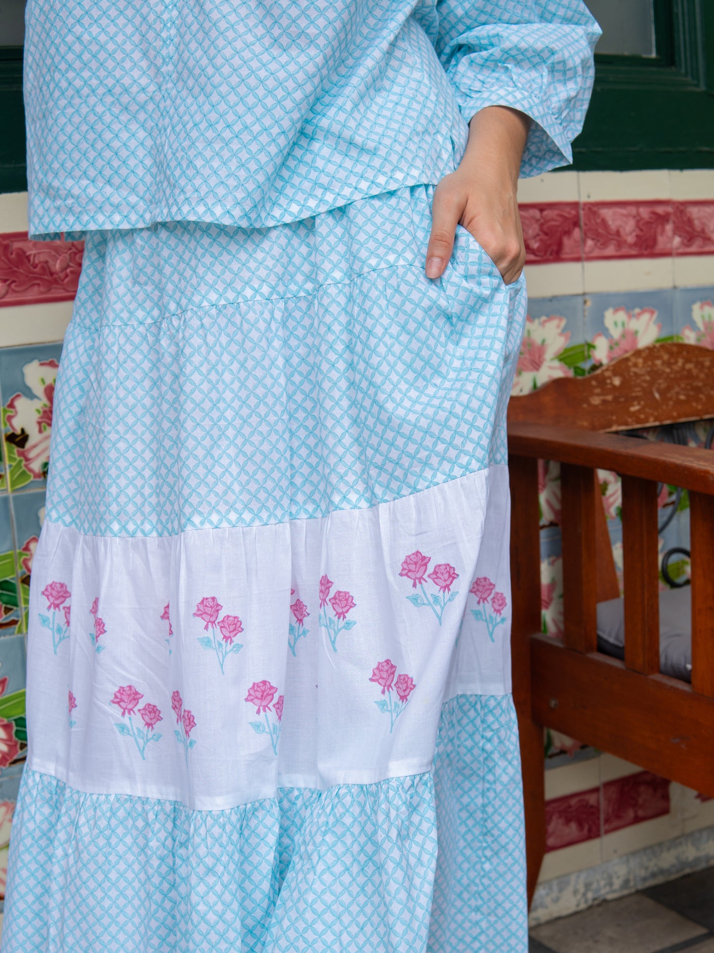 Light blue tiered cotton skirt with rose motifs, block-printed by artisans and inspired by the iconic Peranakan tiles of Singapore.